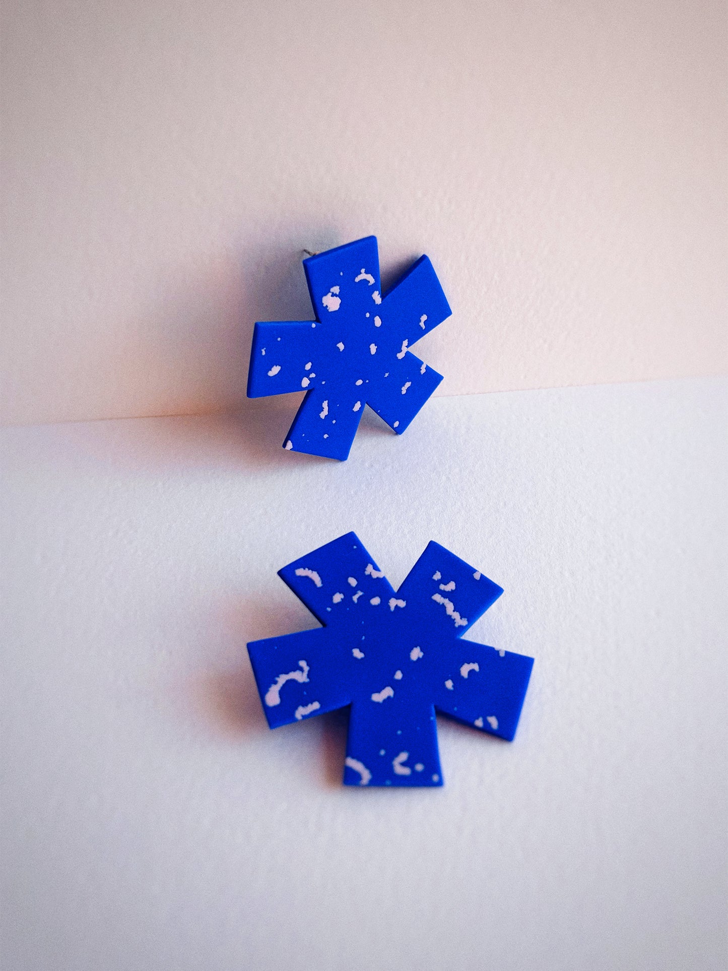 Blue star-shaped earrings on a light background